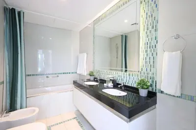 a bathroom with two sinks and a large mirror at 1BR with Balcony, Steps from JBR & Marina Walk in Dubai