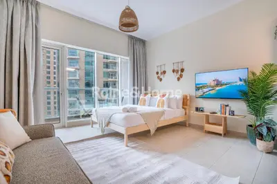 a bedroom with a bed and a large window at RH- Modern studio walk away from Burj khalifa and Dubai Mall in Dubai