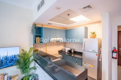 a kitchen with blue cabinets and a refrigerator at RH- Modern studio walk away from Burj khalifa and Dubai Mall in Dubai