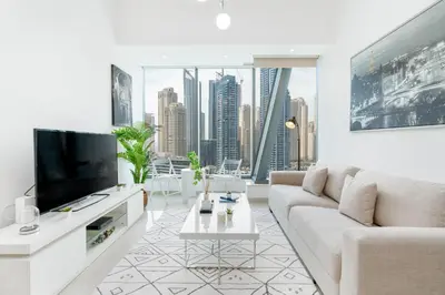 a living room with a couch and a tv at Gala Guests - Silverene Tower Marina Living Apartments in Dubai