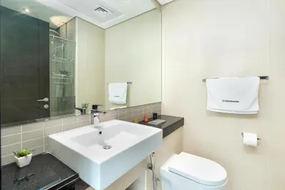 a white bathroom with a sink and a toilet at Gala Guests - Silverene Tower Marina Living Apartments in Dubai