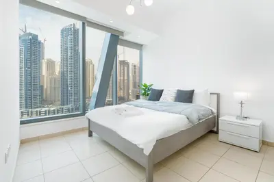 a bedroom with a bed and a large window at Gala Guests - Silverene Tower Marina Living Apartments in Dubai