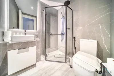 a bathroom with a shower and a toilet and a sink at Peaceful 2BR with Assistant Room at Mesk 1 Midtown Dubai Production City by Deluxe Holiday Homes in Dubai