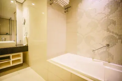 a white bathroom with a tub and a sink at Alashrafia Saray- Splendid 1BR apartment in Canal Views in Dubai