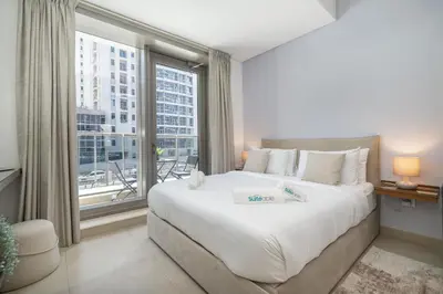 a bedroom with a large bed and a large window at Sleek Studio in Dubai's Vibrant JBR Neighborhood in Dubai