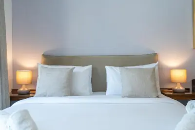 a bed with white pillows and two lamps at Sleek Studio in Dubai's Vibrant JBR Neighborhood in Dubai