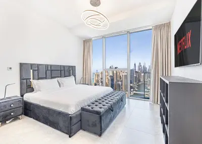 a bedroom with a large bed and a large window at Daniels Marina View 4BR Duplex in Stella Maris in Dubai