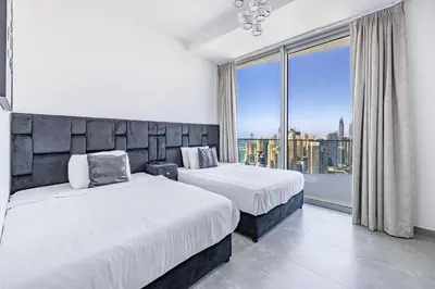 a bedroom with two beds and a large window at Daniels Marina View 4BR Duplex in Stella Maris in Dubai