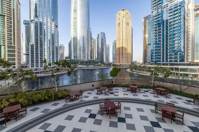a patio with tables and benches in a city at Spacious Apartment I Lake Views Apartment in JLT I Close To Metro in Dubai