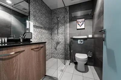 a bathroom with a toilet and a sink at Izzzi Life Mint in Dubai