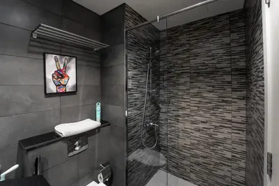 a bathroom with a shower with a glass door at Izzzi Life Mint in Dubai