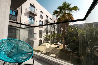 a blue chair sitting on a balcony next to a window at Izzzi Life Mint in Dubai