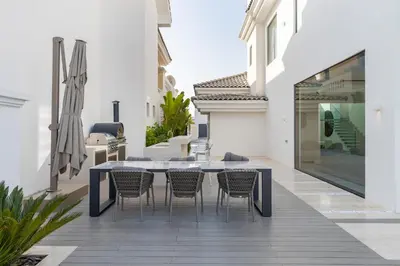 a patio with a blue table and chairs at Palm Jumeirah Paradise - 5BR Villa - Infinity Pool in Dubai