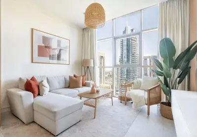 a living room with a white couch and a large window at GuestReady Holiday Homes - Boho Marina Dream in Dubai
