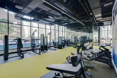 a gym with treadmills and elliptical machines at GuestReady Holiday Homes - Boho Marina Dream in Dubai