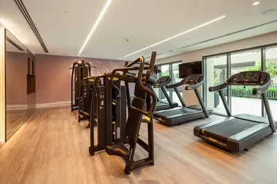 a gym with a row of treadmills and ellipticals at Prime Retreats @ Burj Royale By Emaar in Dubai
