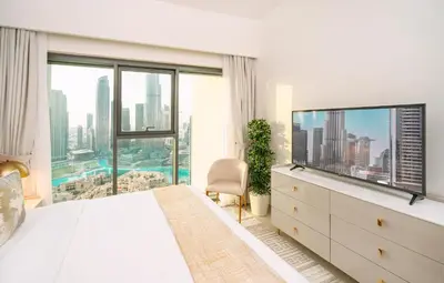 a bedroom with a bed and a large window at Prime Retreats @ Burj Royale By Emaar in Dubai