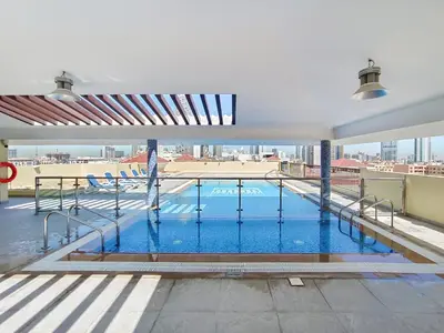 a swimming pool on the roof of a building at Lower floor studio with a sofa bed in JVC - Allsopp&Allsopp in Dubai
