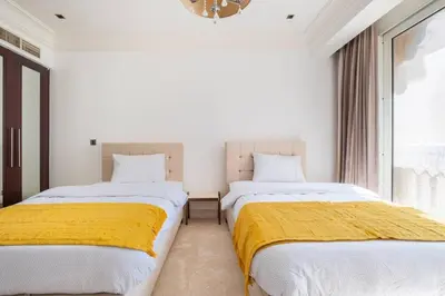 two beds in a room with a window at Spacious 2-bedroom beachfront apartment with pool in Dubai