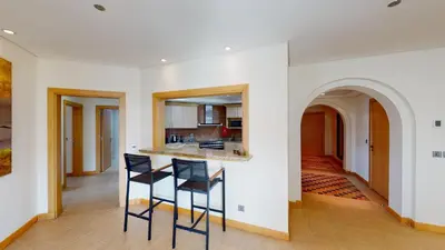 a kitchen and living room with two black chairs at Al Dabas Beach Views, 3BD Sleeps 6, Beachfront Beach & Pool Access - DVH Holiday Homes in Dubai