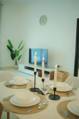 a table with white plates and candles on it at Serene 1BR with Stunning Marina Views in Dubai Marina - The Atlantic in Dubai
