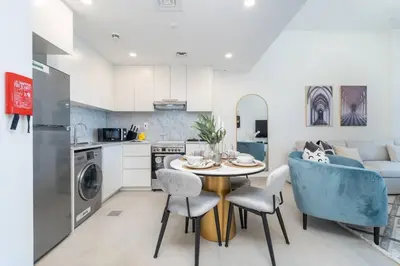 a kitchen and living room with a table and chairs at Vogue Madinat Jumeirah Living Rahaal Near Burj Al Arab One Bedroom Apartment with Balcony and Vibrant Community View, Access to all Amenities in Dubai