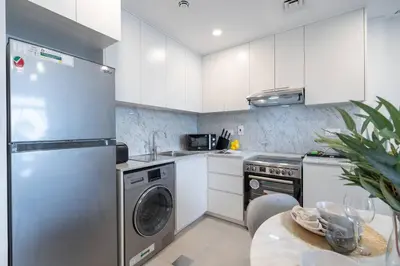 a kitchen with a stainless steel refrigerator and a dishwasher at Vogue Madinat Jumeirah Living Rahaal Near Burj Al Arab One Bedroom Apartment with Balcony and Vibrant Community View, Access to all Amenities in Dubai