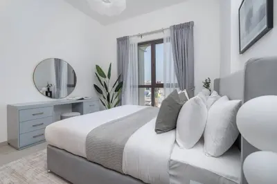 a bedroom with a bed with a mirror and a window at Vogue Madinat Jumeirah Living Rahaal Near Burj Al Arab One Bedroom Apartment with Balcony and Vibrant Community View, Access to all Amenities in Dubai