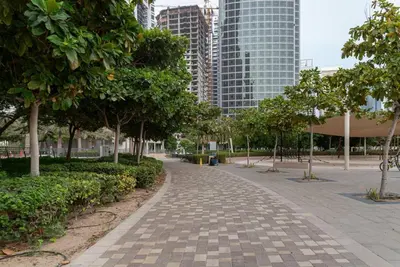 a walkway in a park with trees and buildings at GuestReady - Luxe Studio with JLT Park View in Dubai