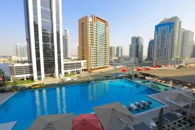 a large swimming pool in a city with tall buildings at Studio - MAG 318 in Dubai
