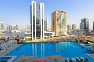 a large swimming pool in a city with tall buildings at Studio - MAG 318 in Dubai