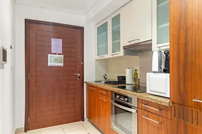 a kitchen with a wooden door and a counter at Silkhaus spacious studio in Boulevard Central with gym & pool in Dubai
