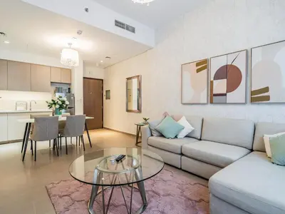 a living room with a couch and a table at Stylish 1BR in Park Heights 2 - Dubai Hills in Dubai