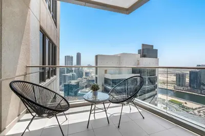 two chairs and a table on a balcony with a view at Silkhaus high floor 1BDR in Southridge in Dubai