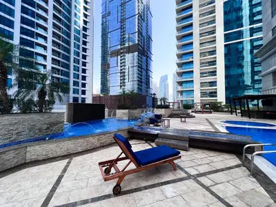 a chair sitting on a patio next to a swimming pool at 76th floor- 2 BR Apartment with Iconic Marina Skyline View in Dubai
