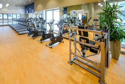 a gym with rows of treadmills and ellipticals at 76th floor- 2 BR Apartment with Iconic Marina Skyline View in Dubai