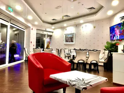 a restaurant with a red chair and a tables and chairs at Cosmos Living Luxurious Studio Near Metro in Dubai