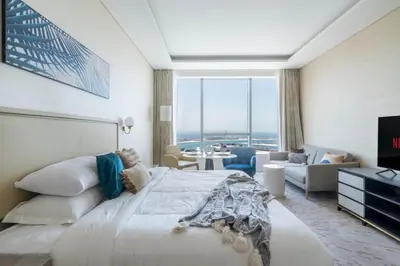 a bedroom with a large bed and a living room at GuestReady - Bejeweled Studio at The Palm Tower in Dubai