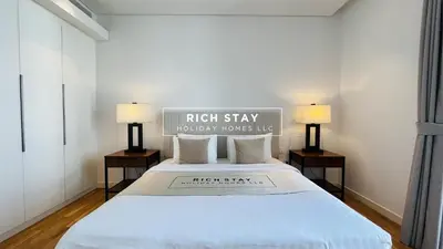 a bedroom with a large bed with two lamps at Crystal Clear 1BR in Blue Waters with Ain View in Dubai