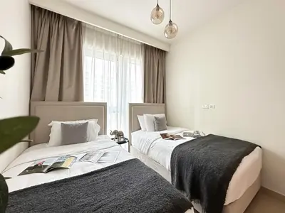 two beds in a room with a window at Trophy Lux 2BR Creek Harbour Suites with Iconic Burj Khalifa Views in Dubai