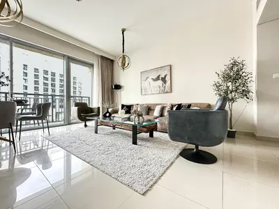 a living room with a couch and a table at Trophy Lux 2BR Creek Harbour Suites with Iconic Burj Khalifa Views in Dubai