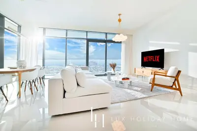 a living room with a white couch and a tv at LUX The ULTRA Luxury Palm Dubai Eye View Suite in Dubai