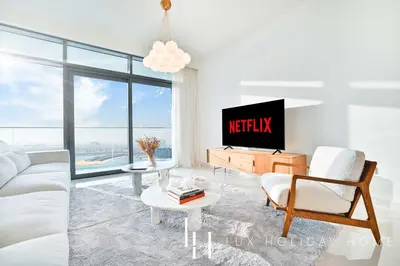 a living room with a white couch and a tv at LUX The ULTRA Luxury Palm Dubai Eye View Suite in Dubai