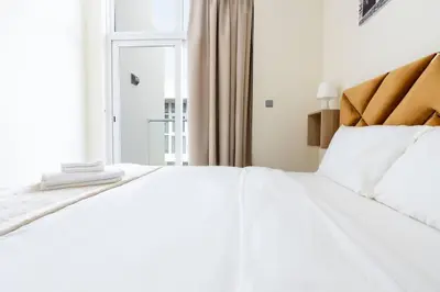 a white bed in a room with a window at Calm Aesthetic 3 Bedroom Villa in Dubai