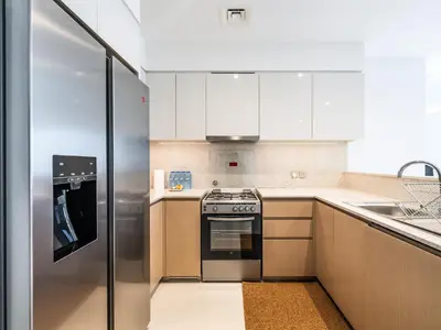 a kitchen with a stove and a refrigerator at Lavishly Elegant 2BR with Breathtaking Full Burj Khalifa View in Dubai