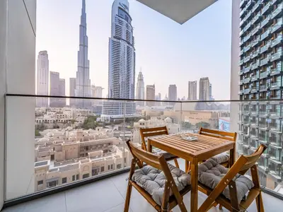 a table and chairs on a balcony with a view of the city at Lavishly Elegant 2BR with Breathtaking Full Burj Khalifa View in Dubai