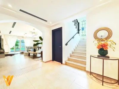 a living room with a staircase and a blue door at Luxury 3BR Private Pool Villa and Elaborate Gardens in Dubai