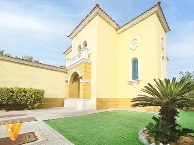 a large yellow church with a green yard at Luxury 3BR Private Pool Villa and Elaborate Gardens in Dubai