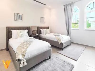 a bedroom with two beds and a window at Luxury 3BR Private Pool Villa and Elaborate Gardens in Dubai