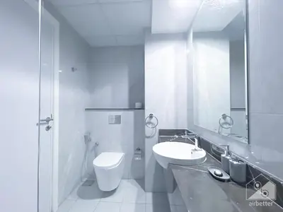 a bathroom with a sink and a toilet and a mirror at NEW! Amazing Studio in Al Majan in Dubai
